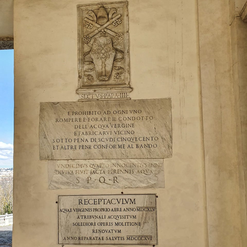 Escudo del papa Sixto IV con una inscripción de mármol que prohíbe dañar el conducto del Acqua Vergine bajo pena de 500 escudos, en la pared de la fuente del Acqua Paola, Roma
