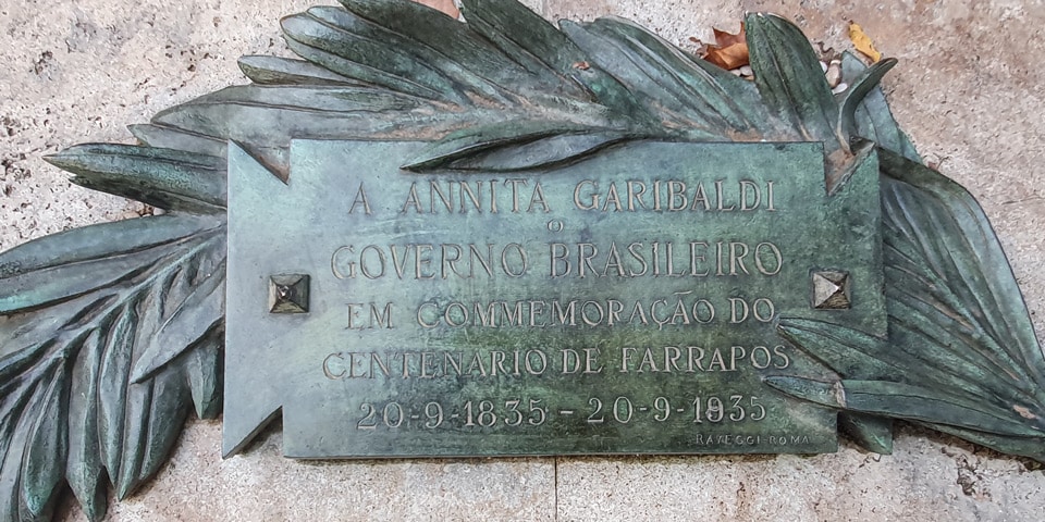 Placa en portugués del Gobierno de Brasil que conmemora el centenario de la Revolución de los Farrapos junto al monumento a Anita Garibaldi