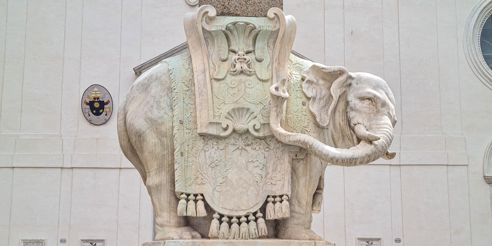 Vista lateral del elefante de Bernini con el drapeado que cubre el soporte central de piedra