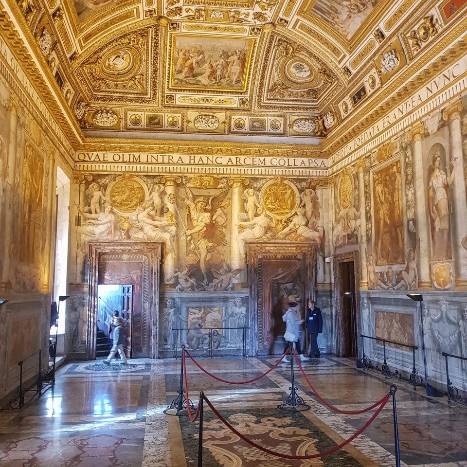 Sala Paolina decorada con frescos, techo artesonado dorado y friso en latín en el interior del castillo de Sant’Angelo, Roma
