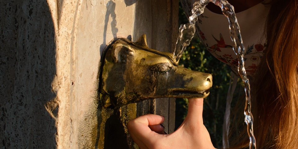 Dedo tapando la salida principal de una fuente de Villa Pamphilj para dirigir el agua por el orificio superior